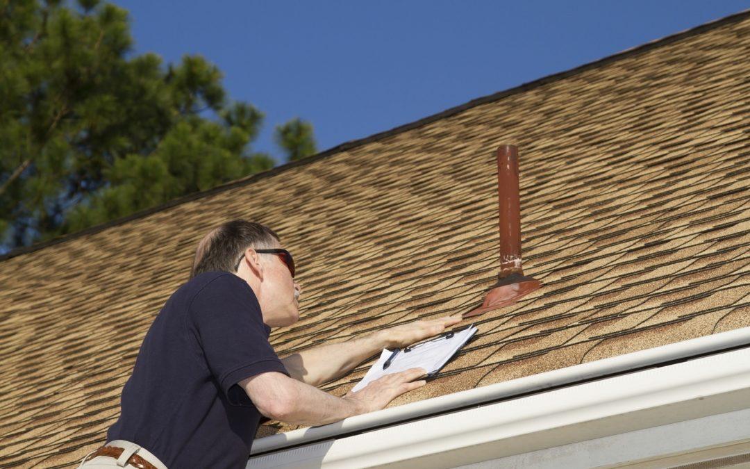 Roofing Contractor Inspecting Longmont Colorado Roof and filling out free roof repair estimate